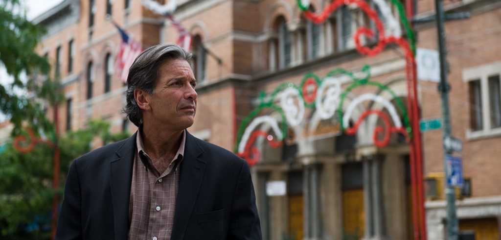 Fordham alumnus Peter Madonia, chief operating officer of the Rockefeller Foundation, stands outside Our Lady of Mount Carmel Church in Belmont.