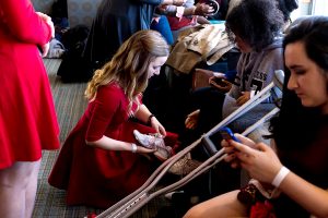 Sami Muller, FCRH '20, a special events coordinator on the Special Olympics executive board at Fordham, helps a Special Olympian get ready for the club's Red Out Fashion Show on Feb. 26, 2017 at the Rose Hill campus. Photo by Jessica Mingrino