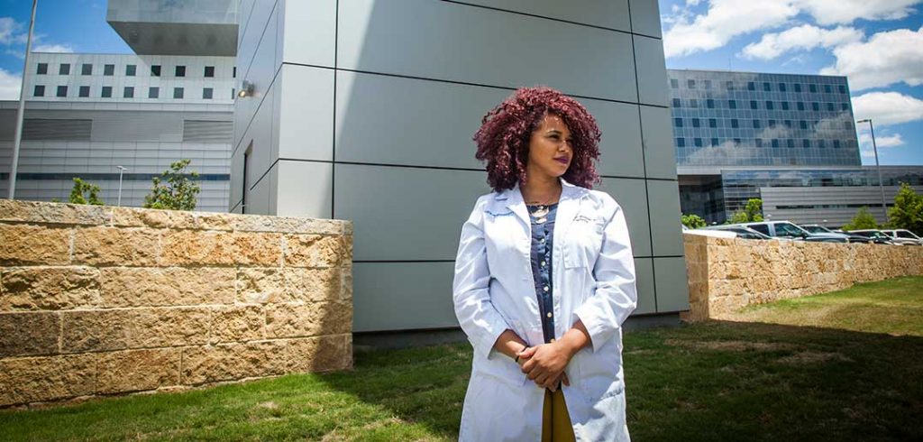 Carli Mendoza in front of Parkland Hospital, part of the UT Southwestern system where she is completing her residency