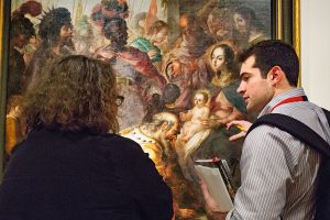 Fordham senior Peter Vergara (right) discusses Villalpando’s work with Ronda Kasl, the Met’s curator of Latin American art. (Photo by Bud Glick)