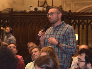 A first-year Jesuit scholastic stands up and, speaking through a microphone, asks Copeland for advice.