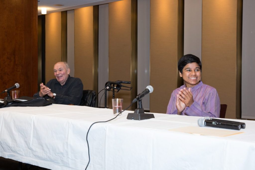 Poets Nausheen Eusuf and Renato Rosaldo at a long table with microphones and a white tablecloth