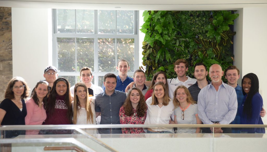 Bren Martini and undergraduate students pose for a picture on the second floor of Hughes Hall. 