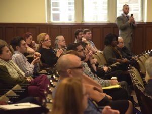 Various men and women sit in the seats in Keating Hall's third-floor auditorium.