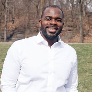 Busayo Ogunsanya standing outside in a park.