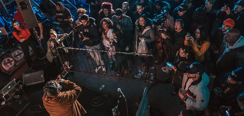 Revelers surround a man with a mic on stage