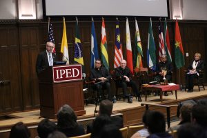 John Briggs addresses an audience from a podium in Keating First Auditorium