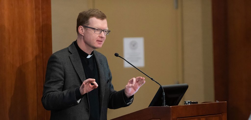 Hans Zollner, S.J. speaks from a podium