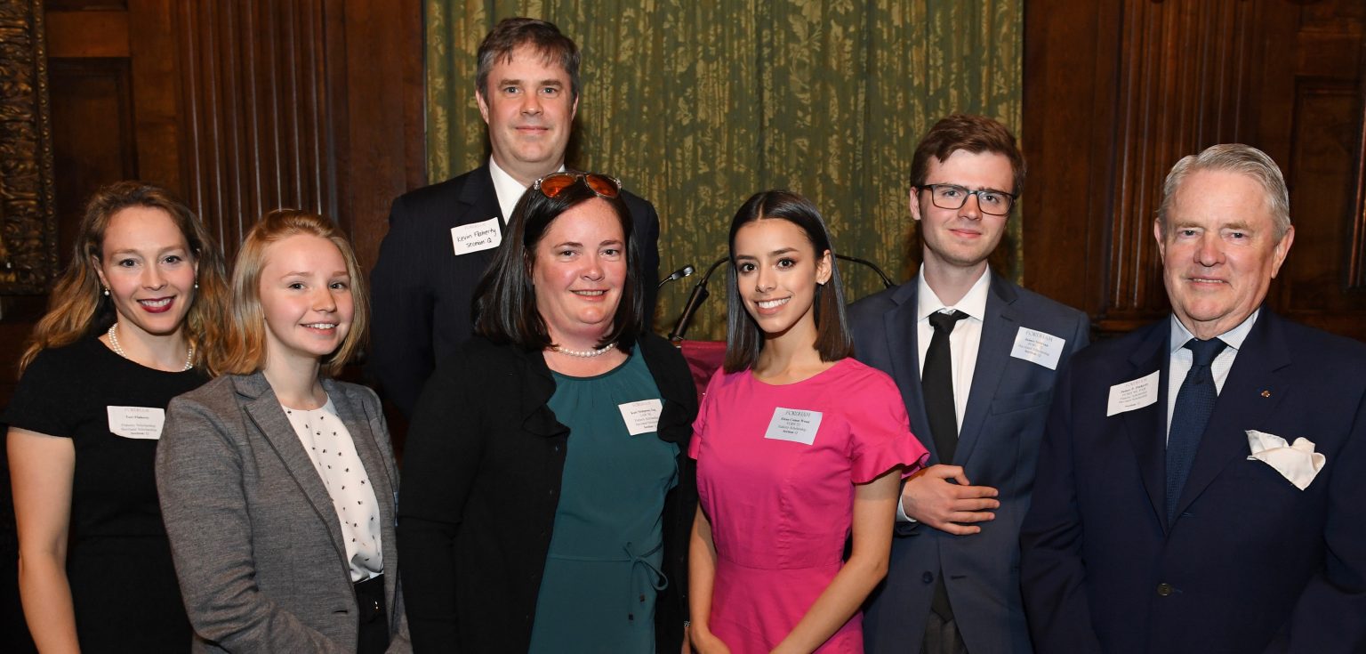 James Flaherty poses for a formal photo with six of his scholarship recipients.