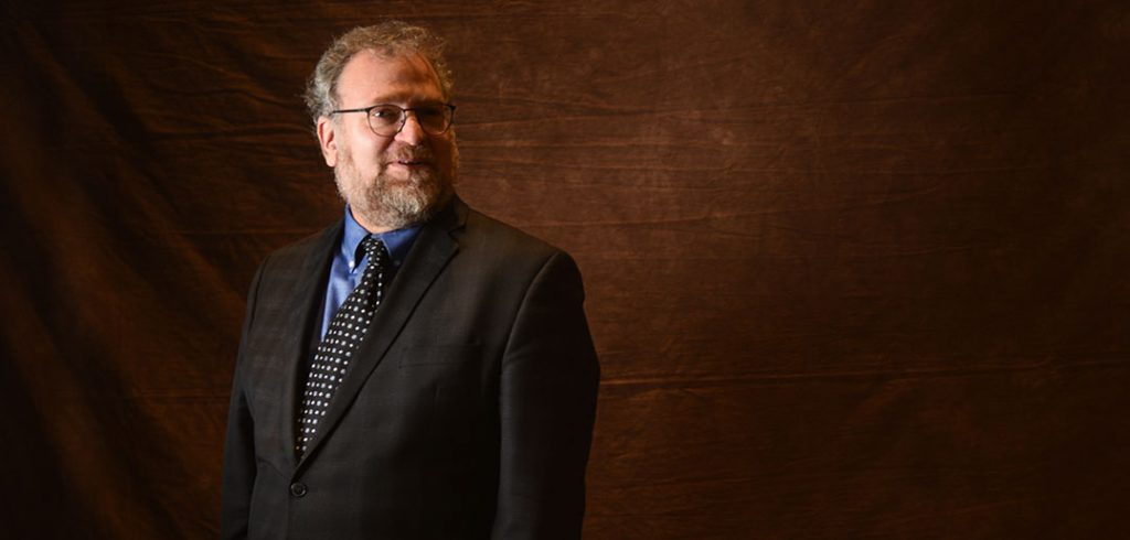 Saul Cornell standing in front of a brown background