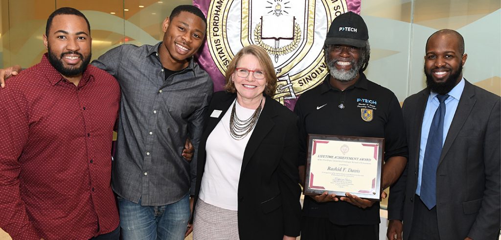 P-TECH staff and alumnus celebrate Rashid Davis's award, from left: Cordel Blair GSE '17, assistant principal; Radcliffe Saddler, recent graduate; GSE Dean Virginia Roach; Rashid Davis, GSE '03; and Victor John, assistant principal.