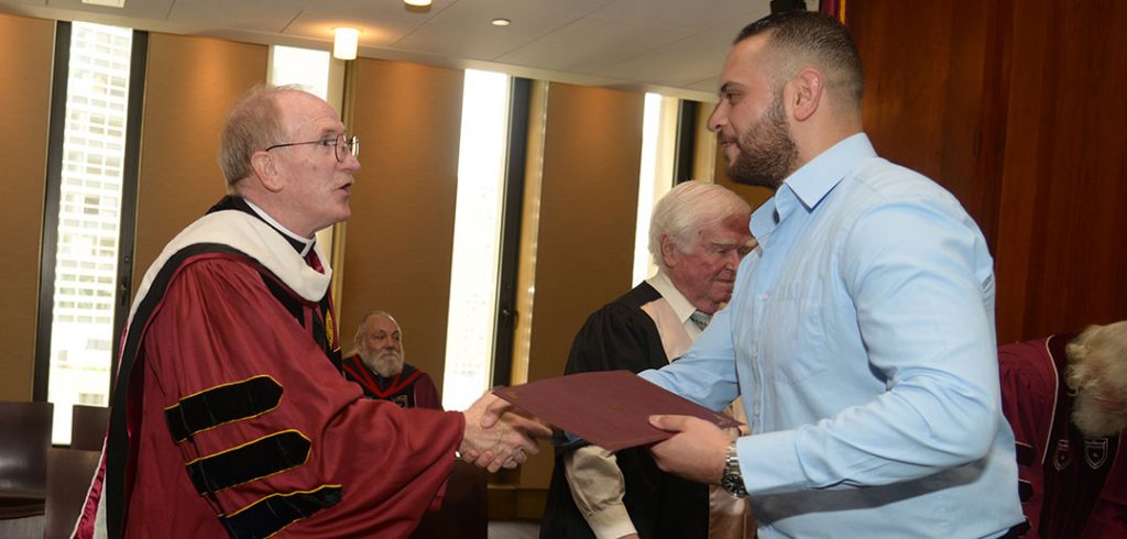 Father McShane congratulates an IDHA graduate.