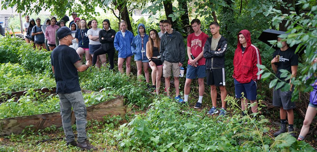 Mario Figueroa , at left, explains the history of the garden to students. 