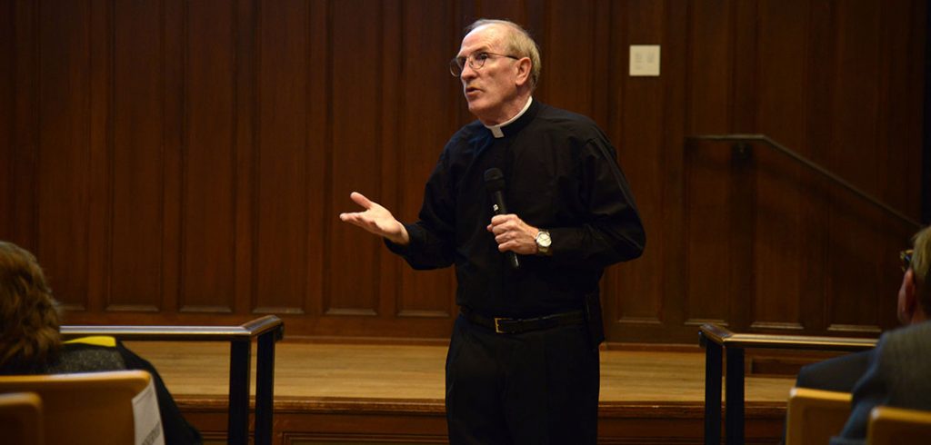 Joseph M. McShane standing, talking into a microphone