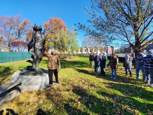 Dean Reilly stands in front of a statue