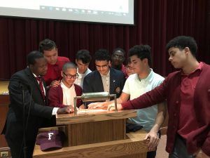 Several men huddled together around a podium