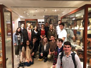 Students standing together in front of museum exhibit cases.