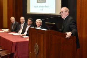 Father McShane speaking at a podium