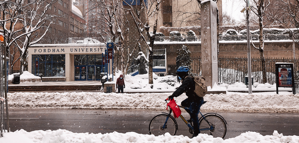 Bicycle going by snowy entrance to Fordham's Lincoln Center campus