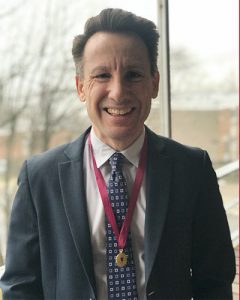 Man in suit wearing medal around neck