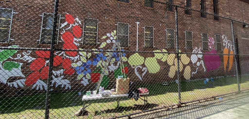 A fruit and vegetable garden mural on a brick wall