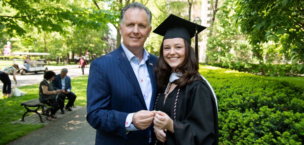 A man poses with his daughter at graduation