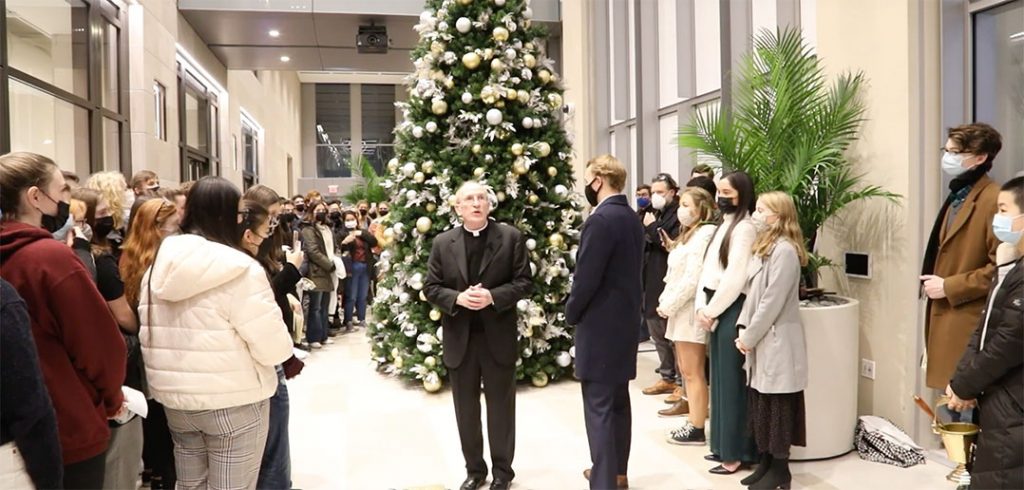 Joseph M McShane standing in a room surrounded by students