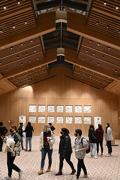 students walking past the stations of the cross in the multipurpose space