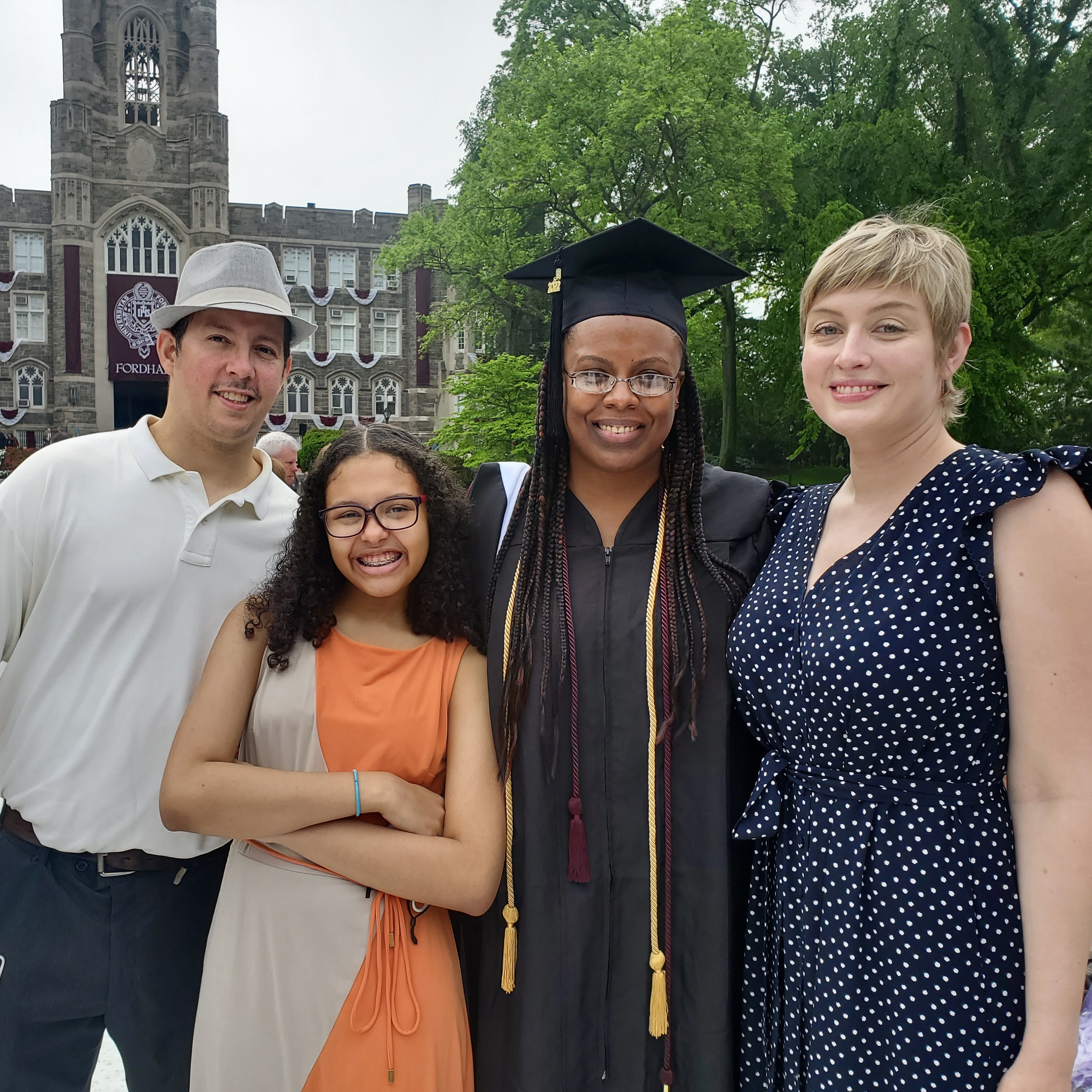 Three people and a child smile.