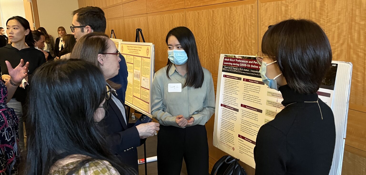 People speak in front of a research poster.