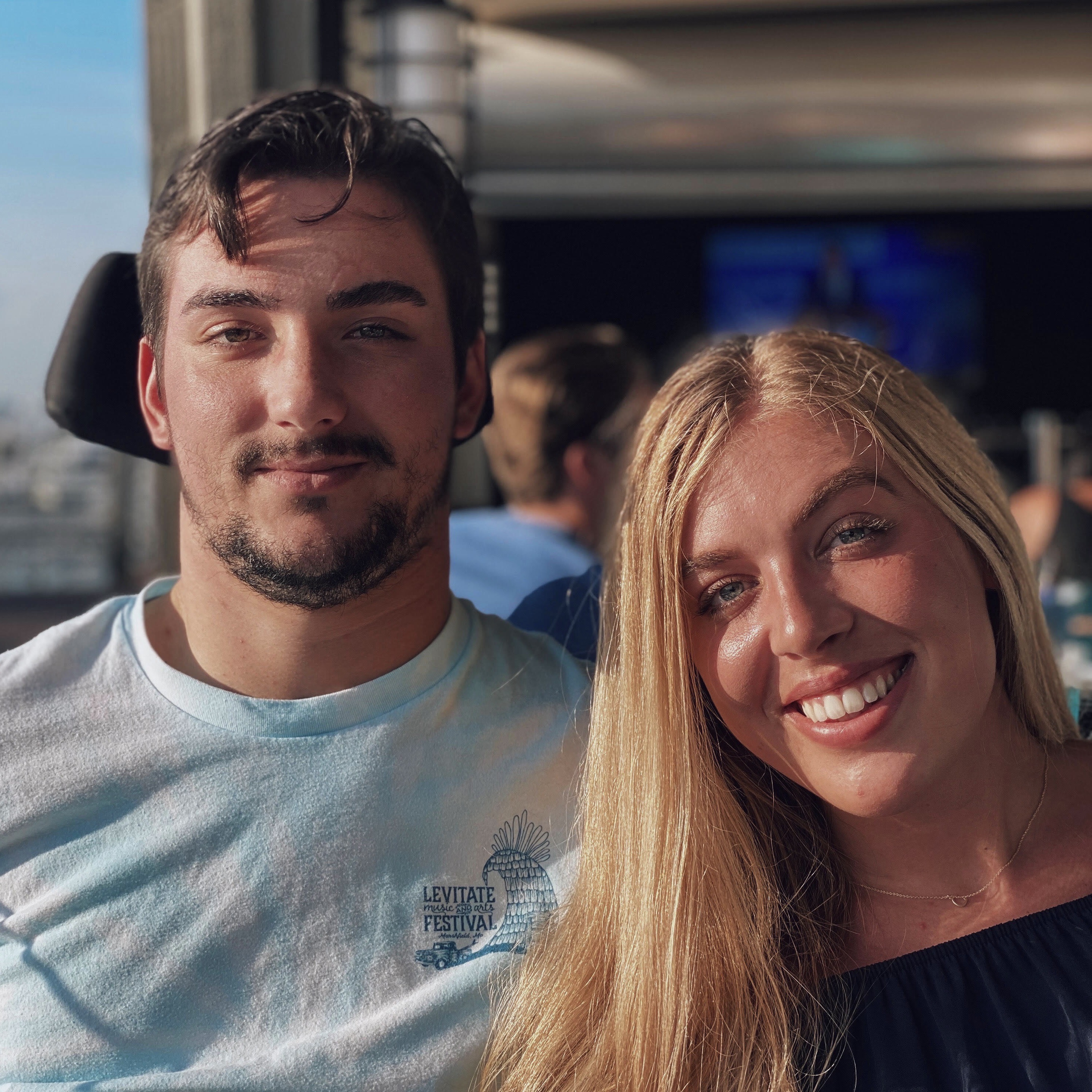 A young man and a young woman smile.