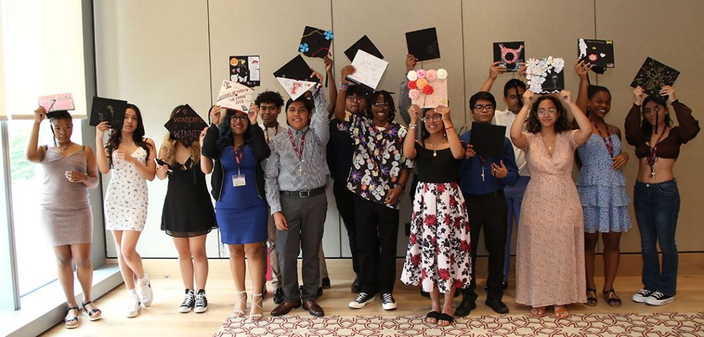 graduates posing in line in caps and gowns