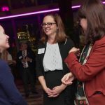 Three women speak with each other.