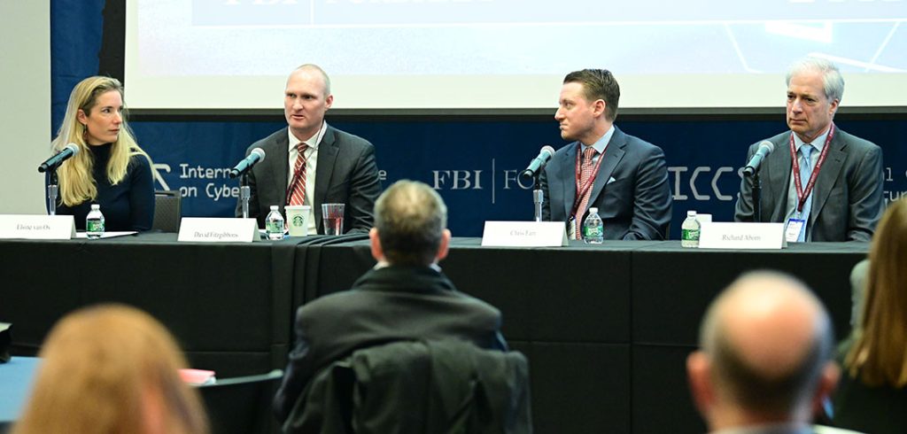 Four people seated at a table in front of an audience