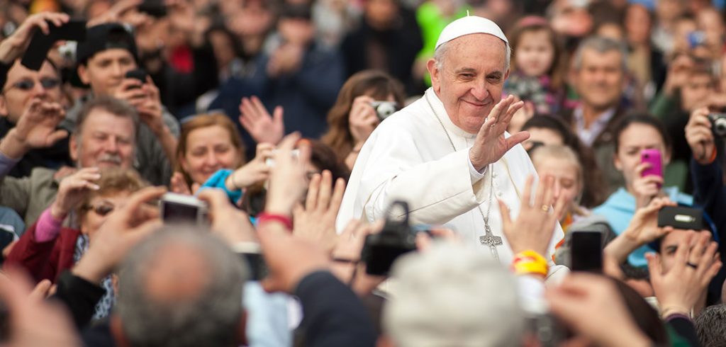 Pope Francis waving to crowds surrounding him