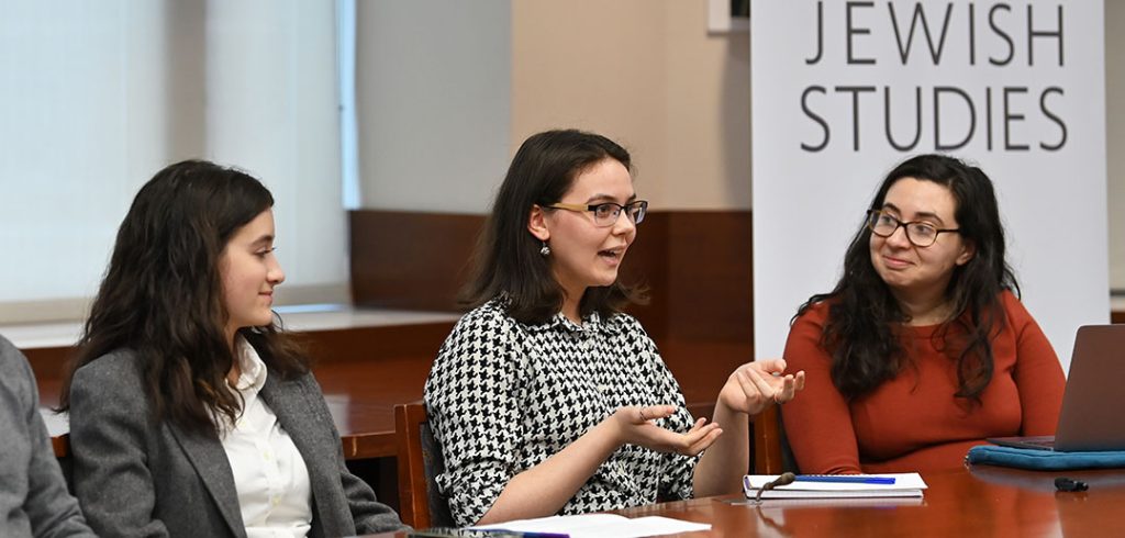 Three women talk on a panel