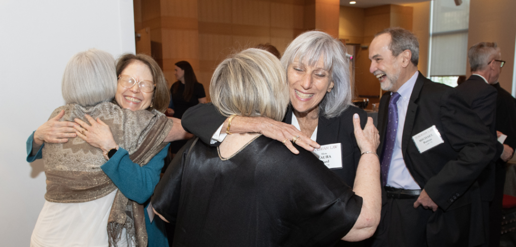 Two pairs of women hugging each other.