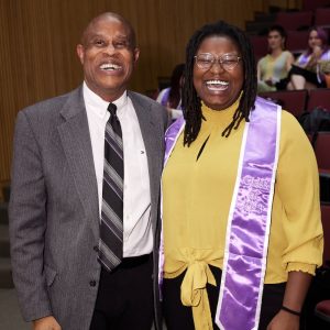 A man and a woman smile at the camera.