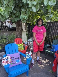 a woman standing next to chairs and books