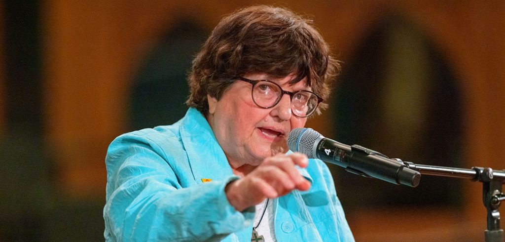 Sister Helen Prejean speaks at a microphone in front of the crowd at St. Paul the Apostle Church