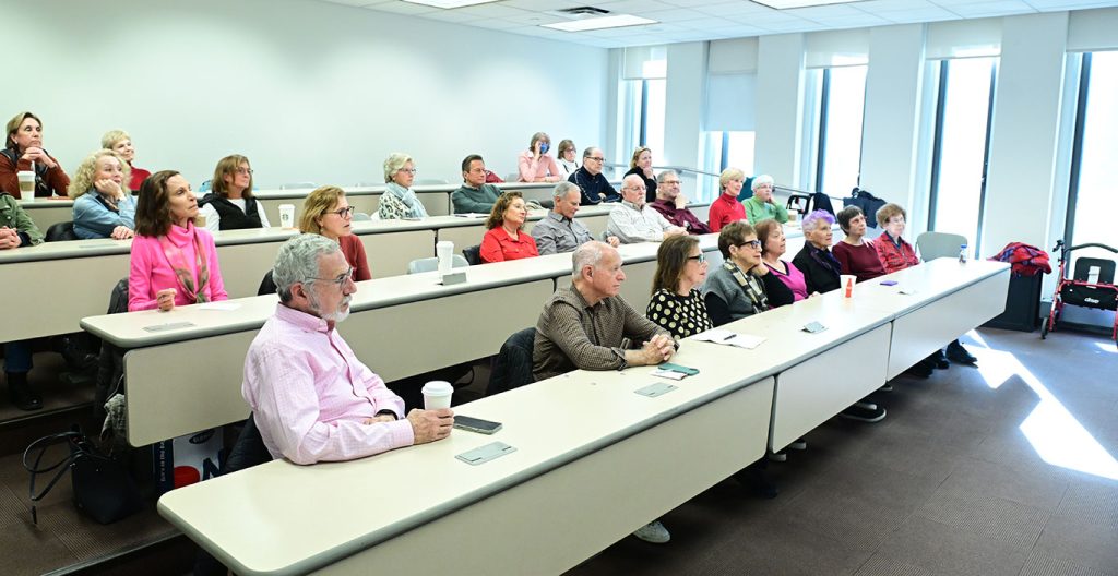 people seated at desks in a classroom