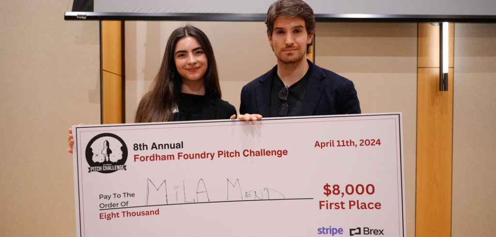 Two people hold a check