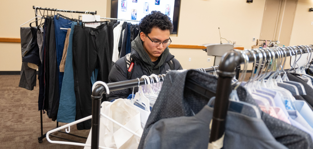 A student looking through a clothes rack.