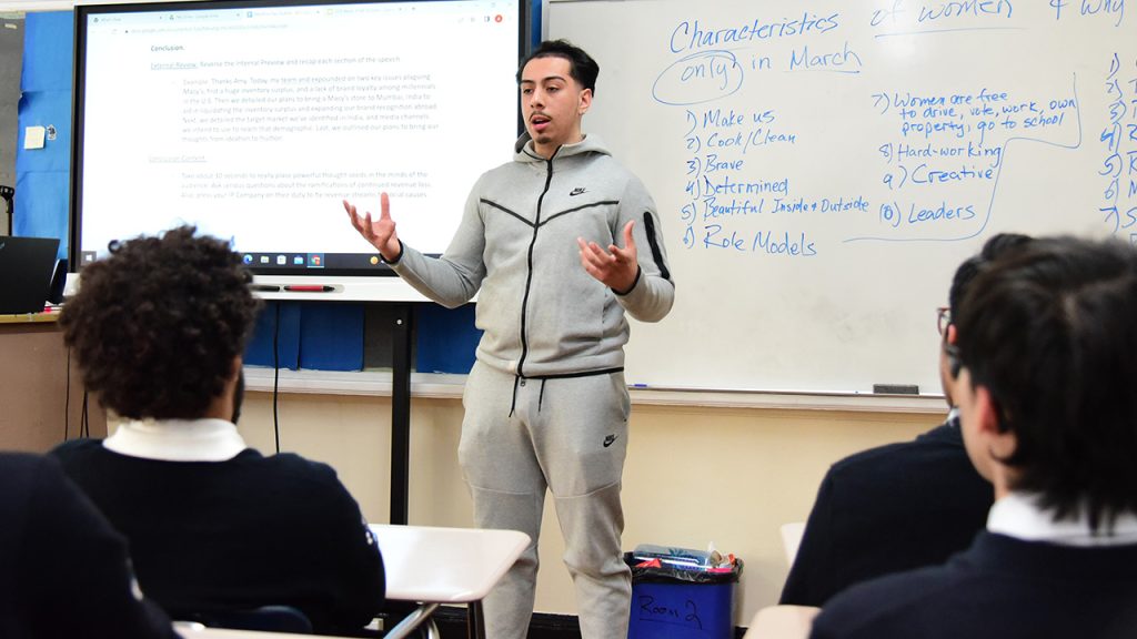 Gabelli School student Andres Cintron teaching a class at All Hallows High School in the Bronx