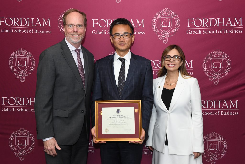 Three people standing at Fordham's Leon Lowenstein Center at the Gabelli School of Business: Fordham’s Provost Dennis Jacobs, Ph.D., with the Robert Bendheim Chair in Economics and Financial Policy, An Yan, Ph.D., and Gabelli School Dean Lerzan Askoy, Ph.D. at the Leon Lowenstein Center. Photo by TK
