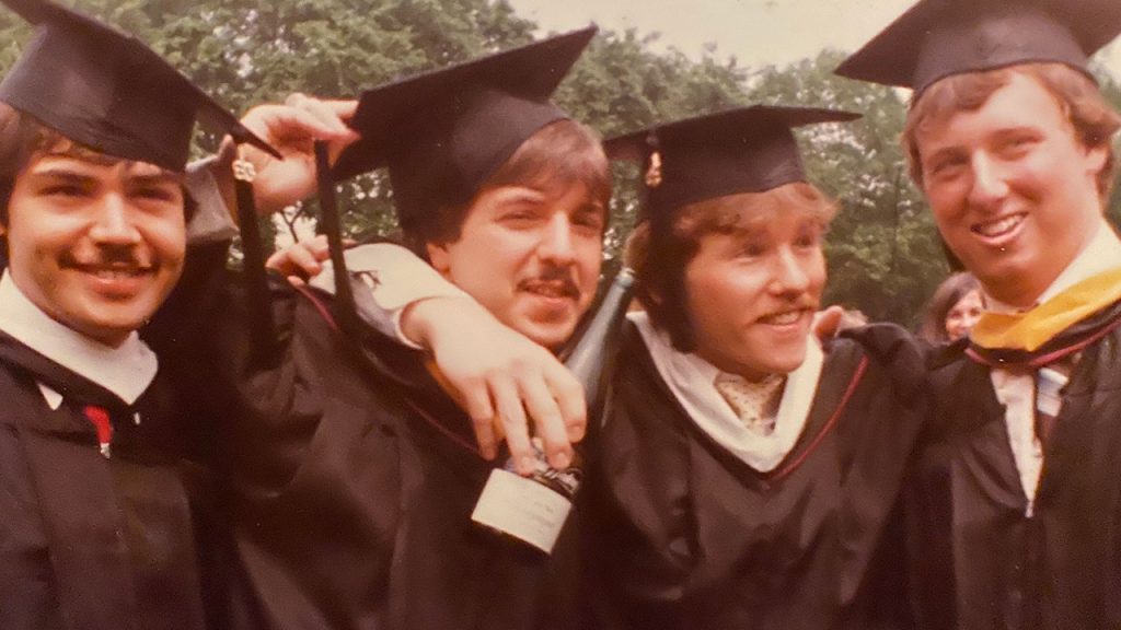 Four Fordham graduates pose at commencement in 1983.