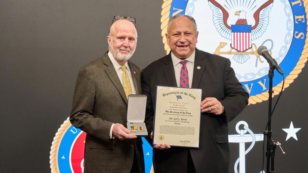 Gerry Byrne posing with Carlos Del Toro, secretary of the Navy, at the ceremony for his U.S. Navy Distinguished Public Service Award